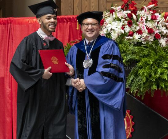 A graduate receives his degree from President Swallow.